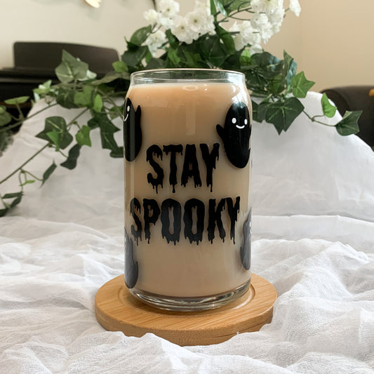 Stay spooky glass can with happy ghosts filled with iced coffee.