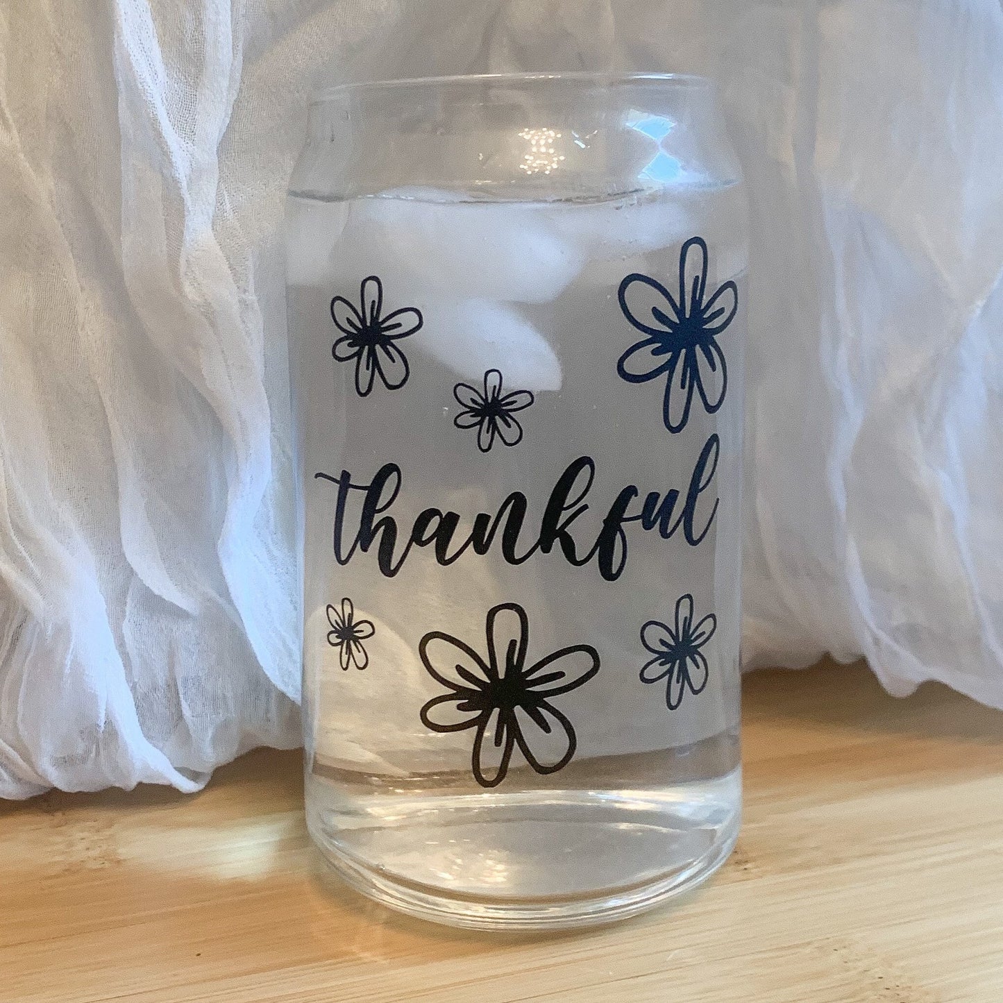 Floral Thanksgiving glass filled with cold water and ice cubes.